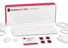 Raspberry Pi 500+ Desktop Kit white keyboard mouse power adapter cables and setup guides beside the box